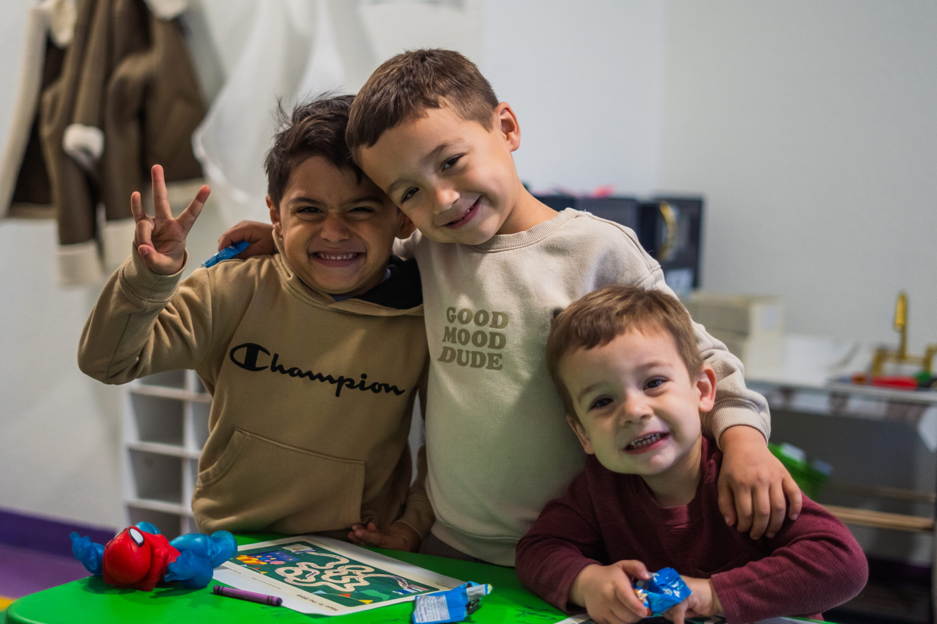 Three happy boys smiling and posing together indoors.