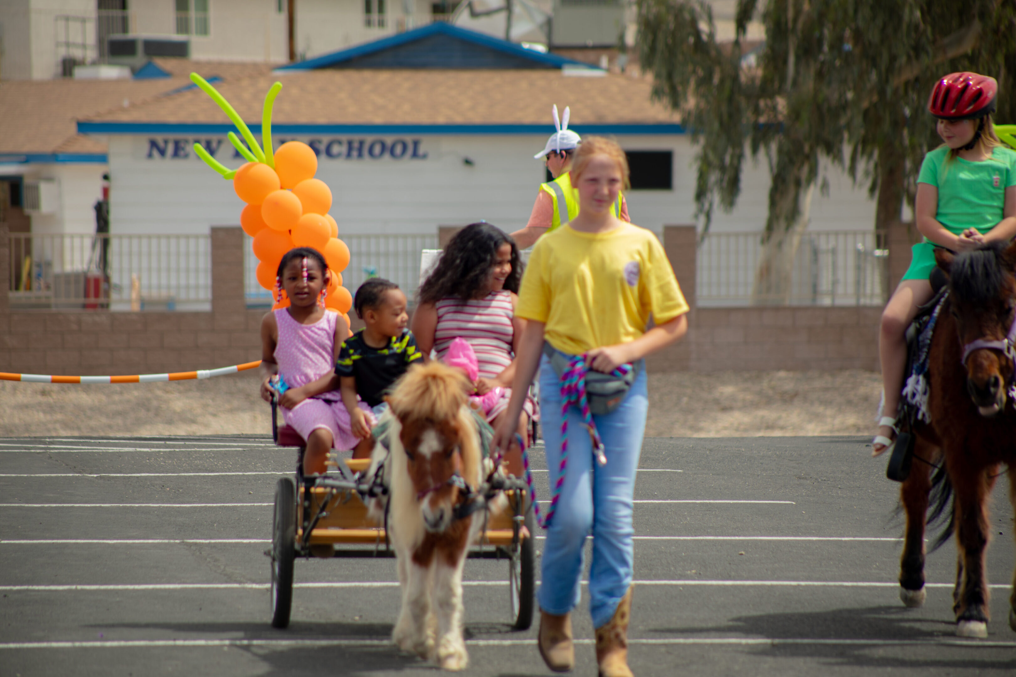 Children dressed in colorful costumes, one riding a pony, in a playful parade.